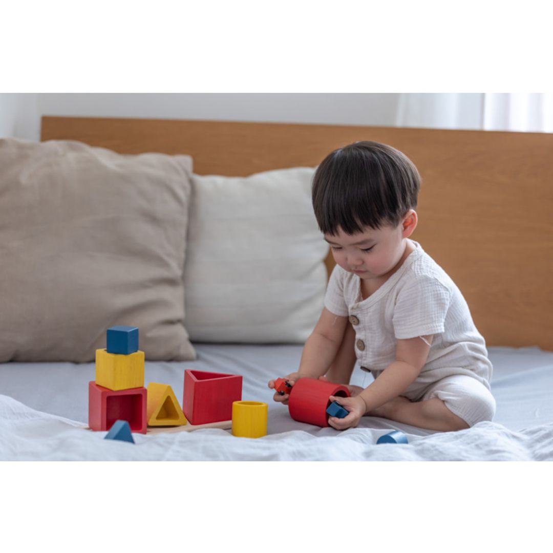 Child playing with colorful building blocks on a bed