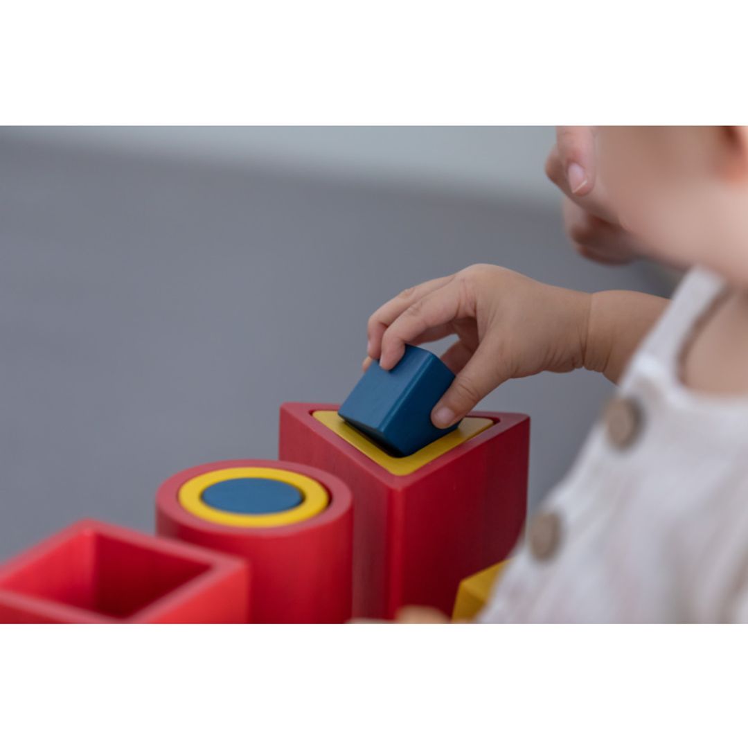 Child playing with colorful building blocks on a gray background