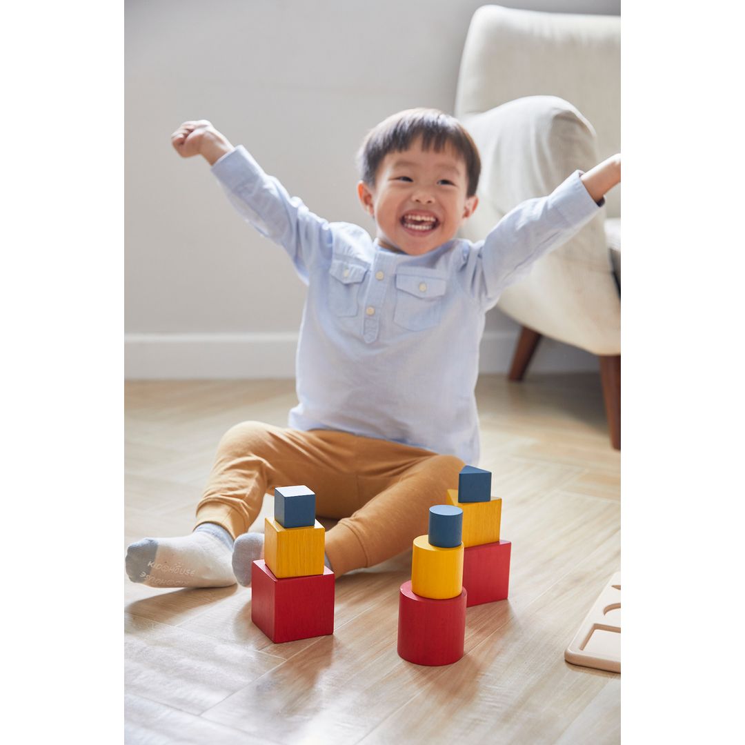 Child playing with colorful building blocks on a wooden floor
