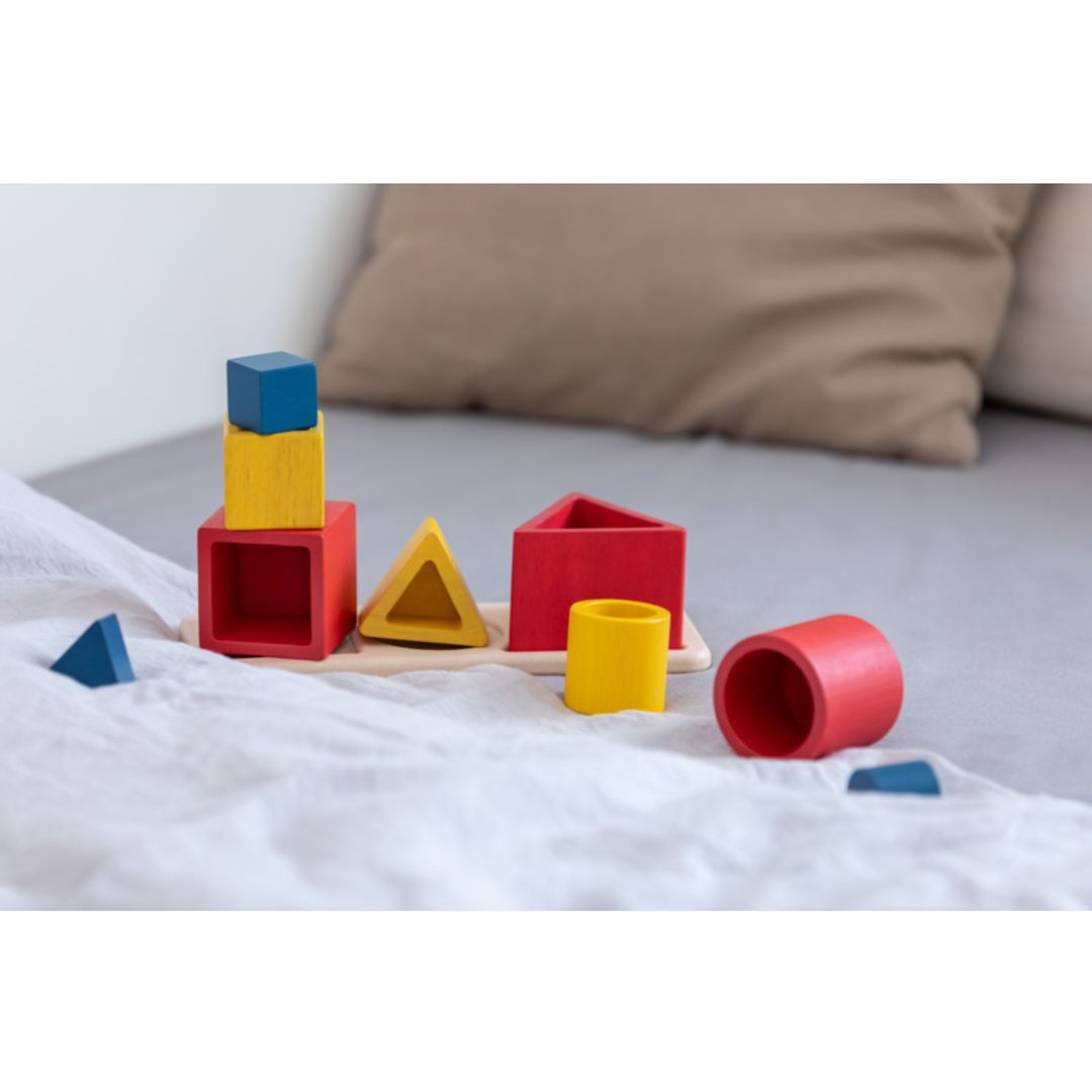 Colorful toy blocks on a bed with pillows in the background