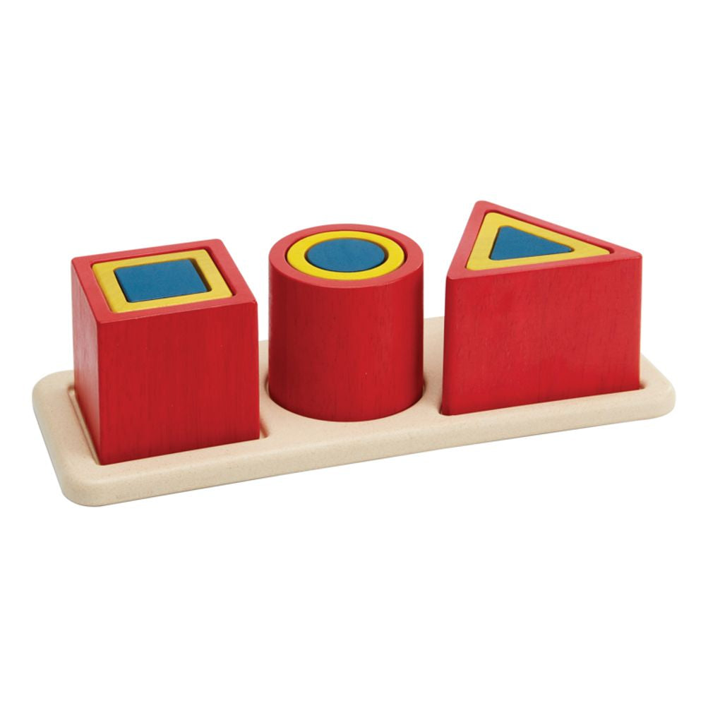 Set of red geometric shape blocks on a wooden tray with blue and yellow accents.