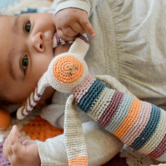 Baby playing with a colorful striped rattle toy