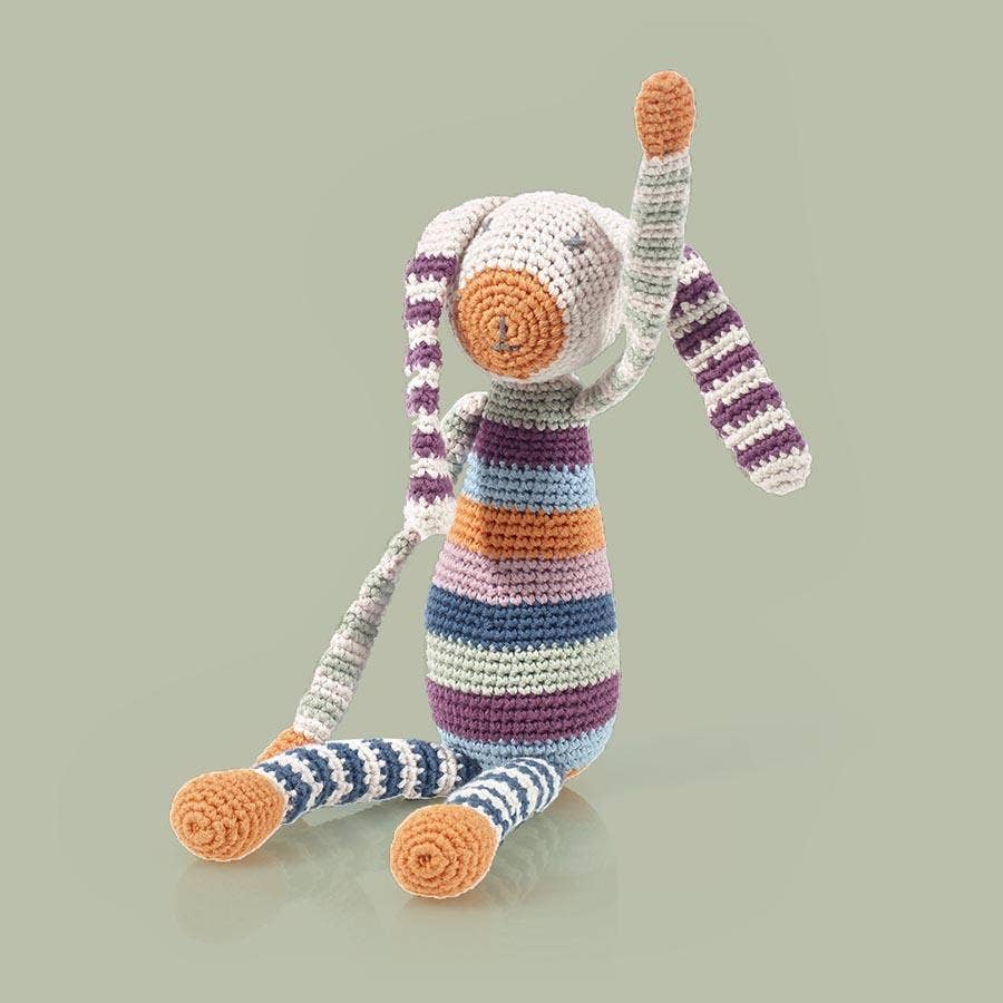 Striped crochet toy with orange accents on a light gray background