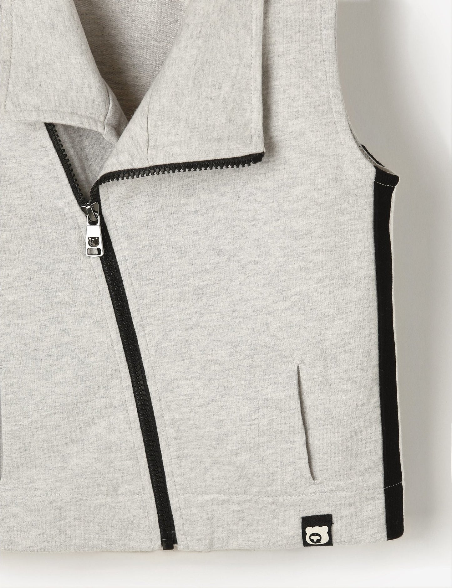 Gray vest with black zipper and trim on a light gray background