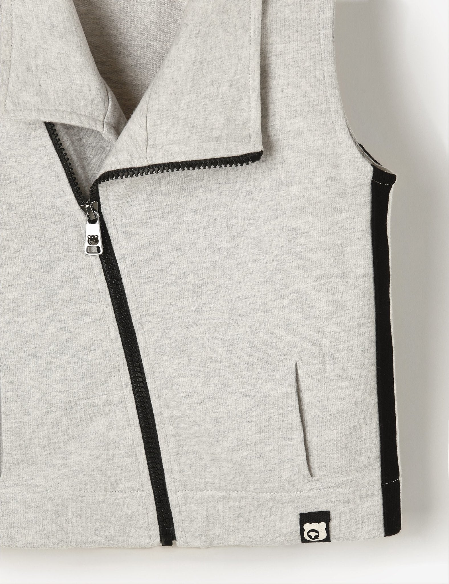 Gray vest with black zipper and trim on a light gray background