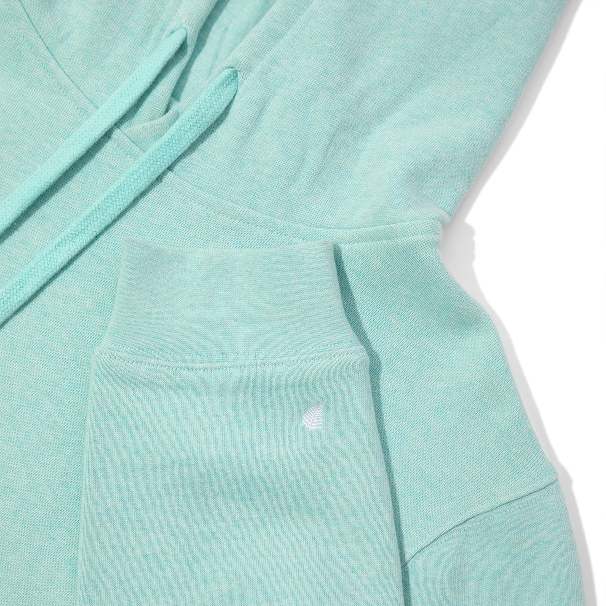 Close-up of a light blue hoodie with a pocket on a white background