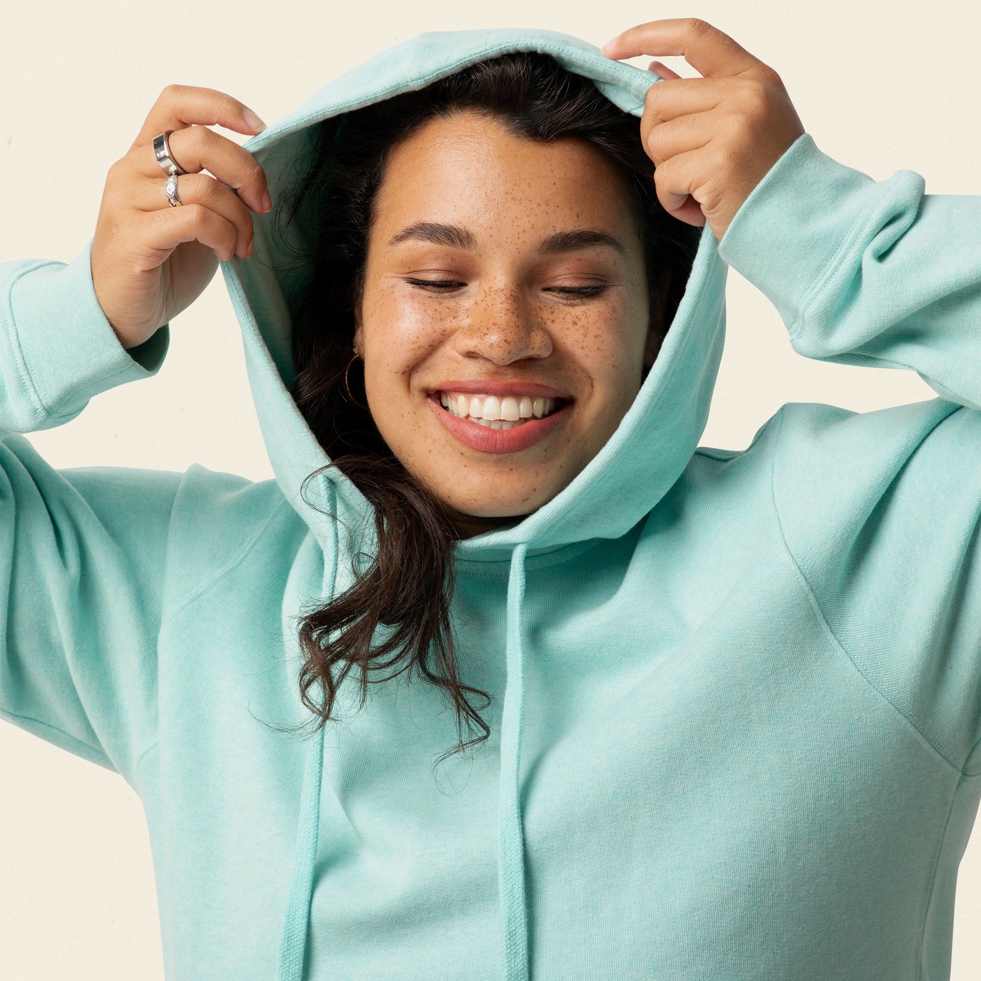 Person wearing a light blue hoodie with a neutral background