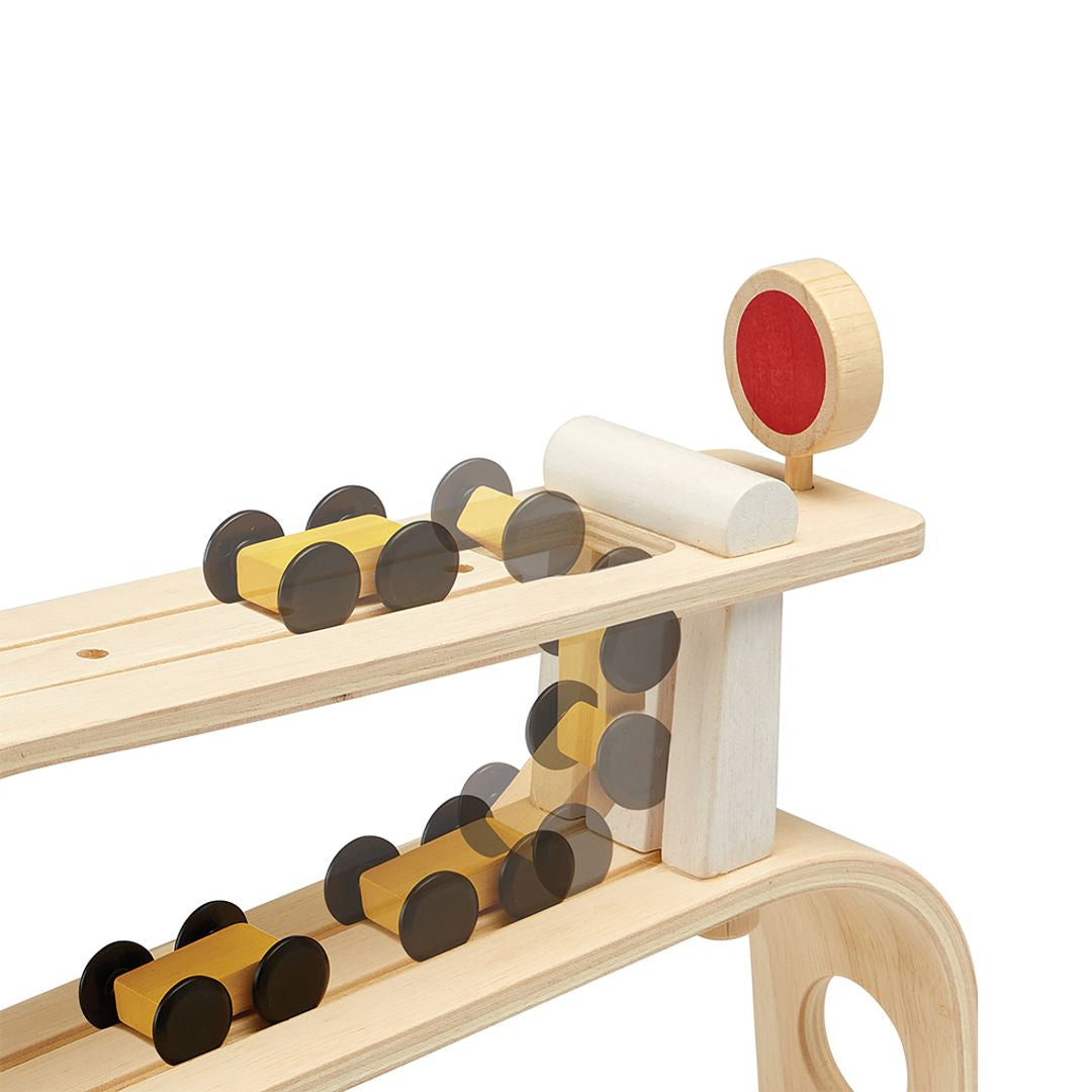 Wooden toy train set with tracks and a red circle on a white background