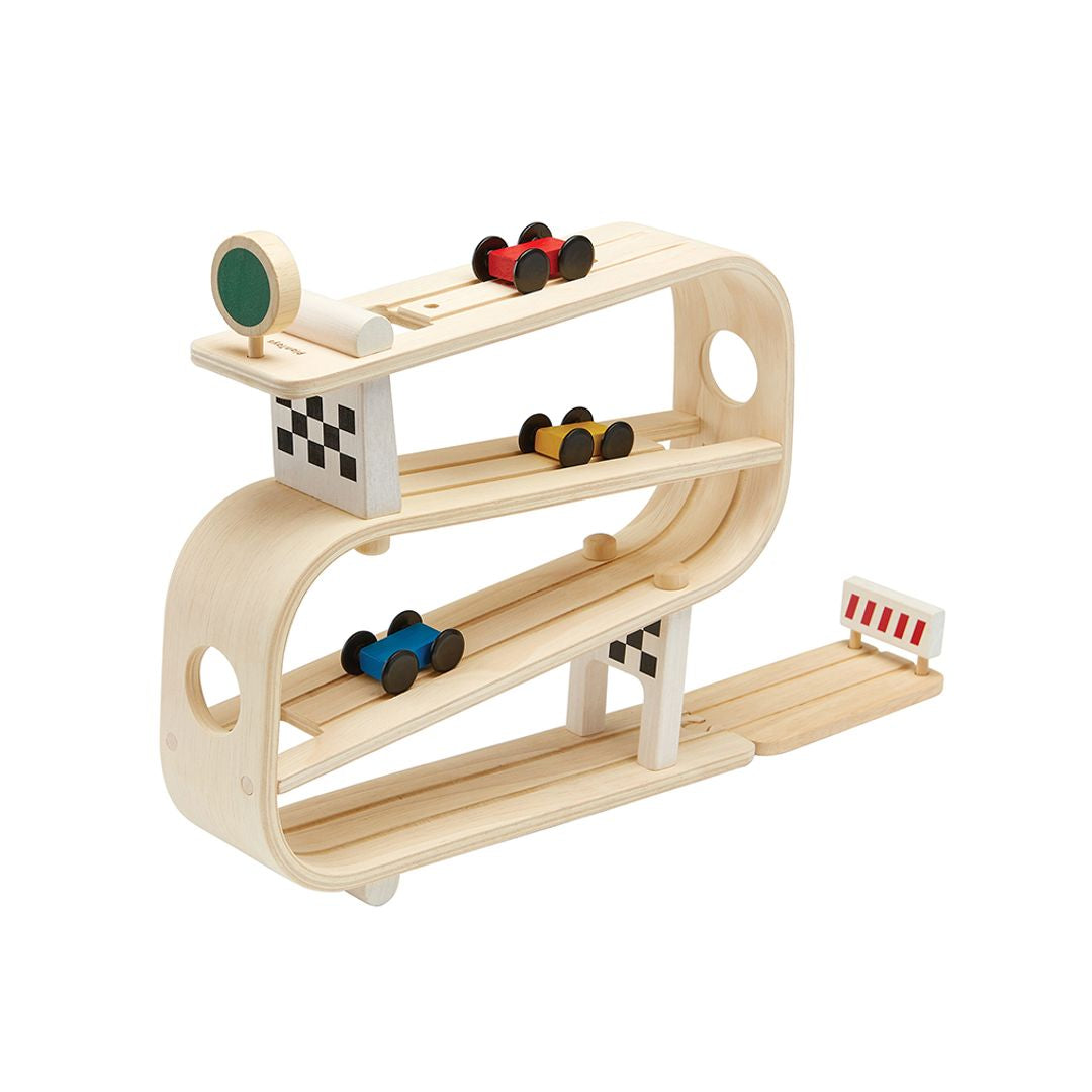 Wooden toy race track with cars on a white background