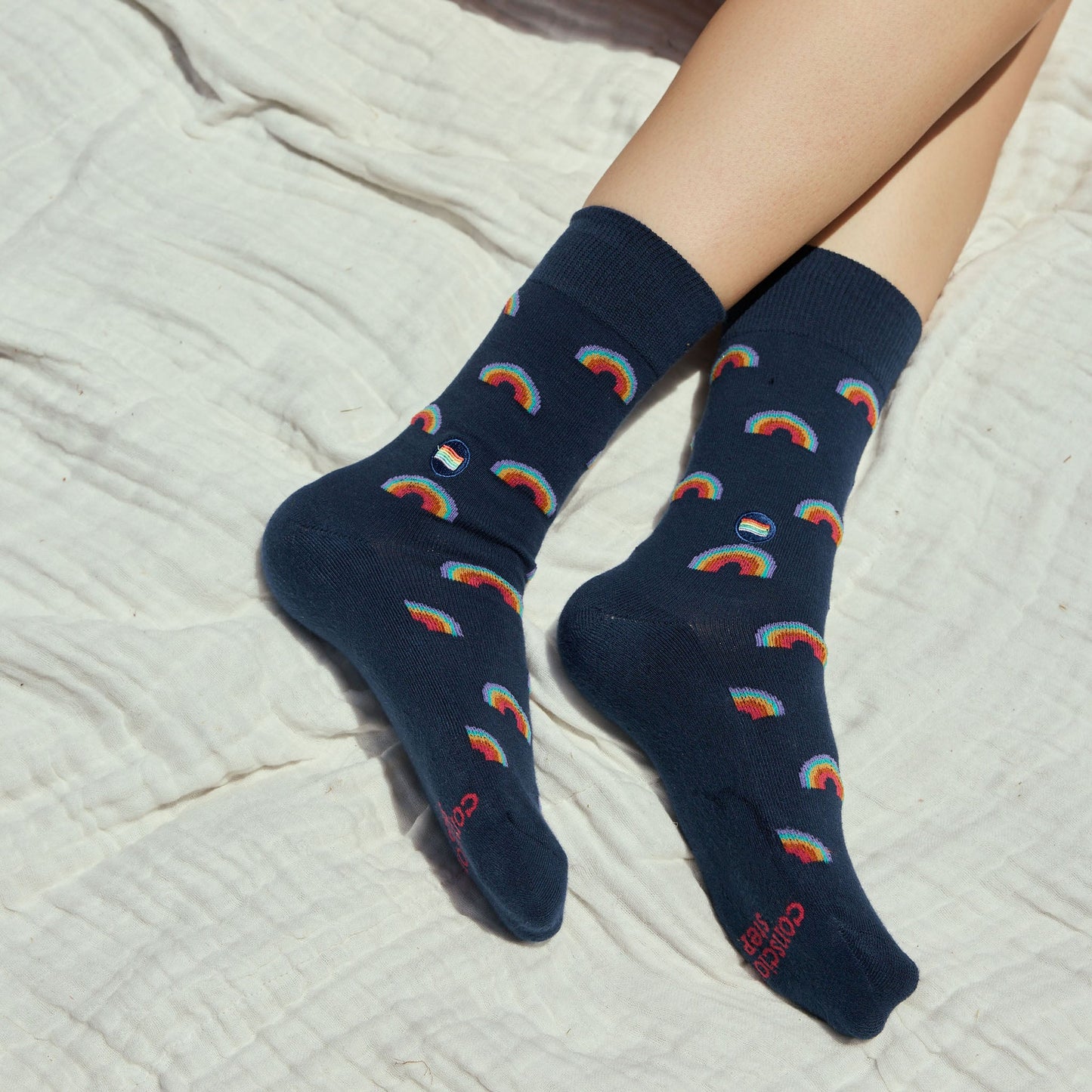 Navy socks with rainbow patterns on a light fabric background