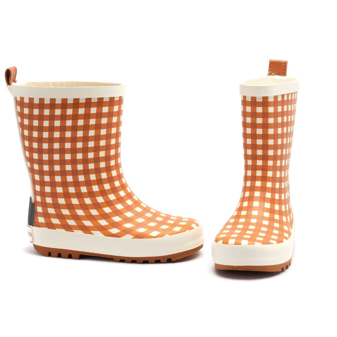 Pair of orange checkered rain boots on a white background