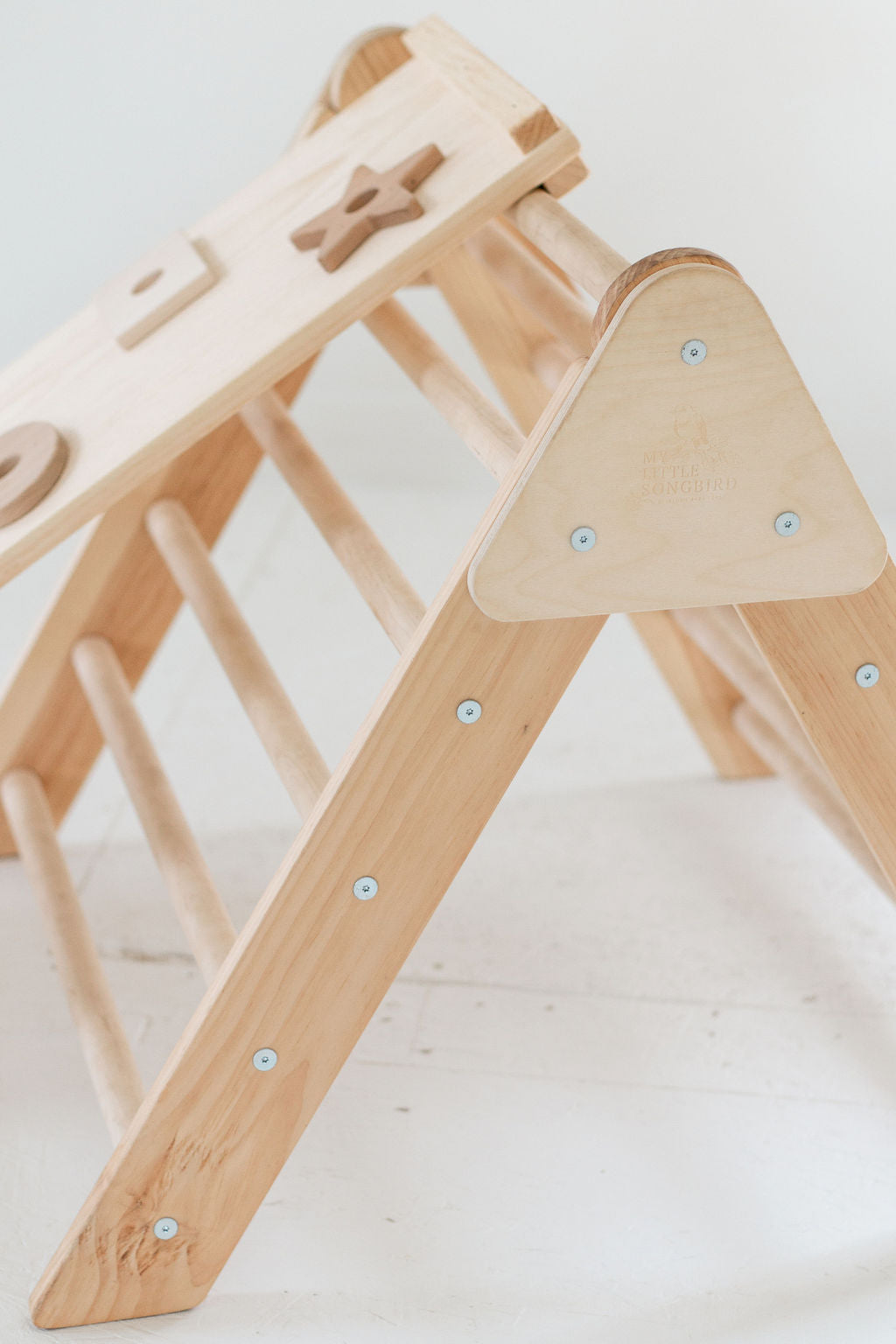 Wooden climbing toy with a ladder and platforms on a white background