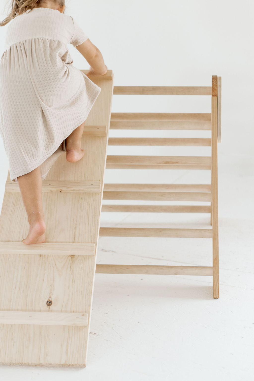 Child climbing a wooden ladder on a white background