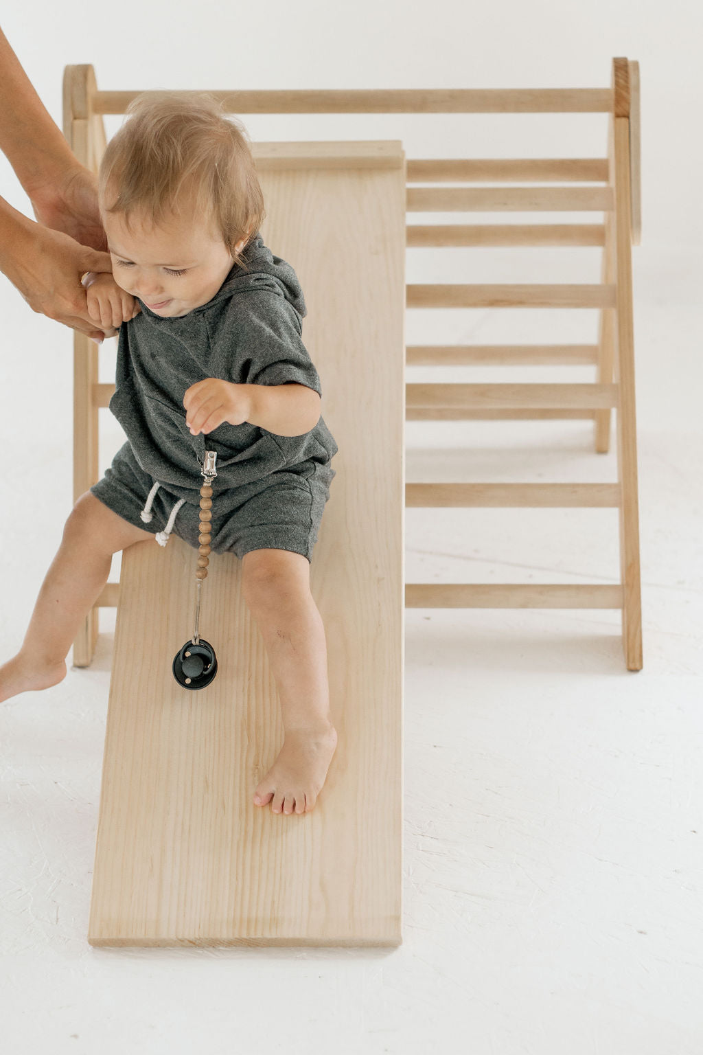 Child playing with a wooden toy on a white background