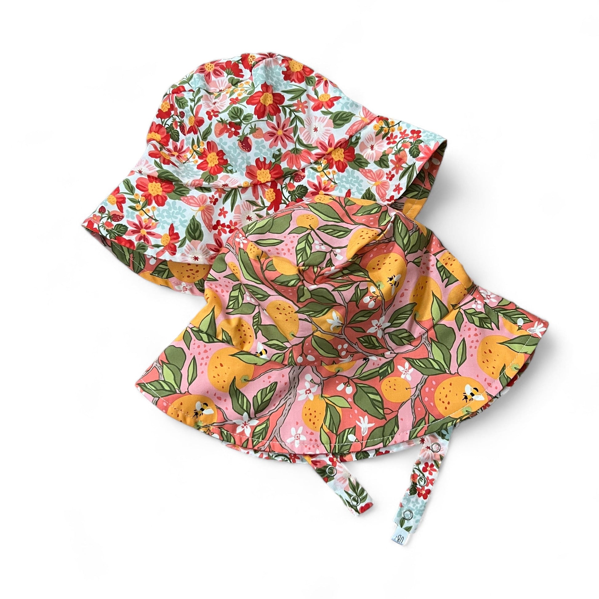 Two colorful headscarves with floral and fruit patterns on a white background