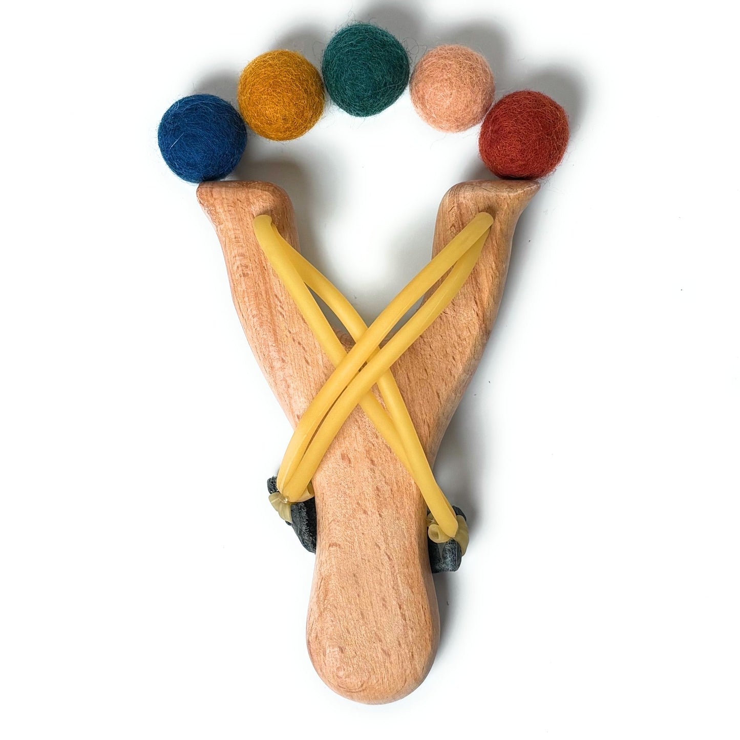 Wooden slingshot with colorful balls on a white background