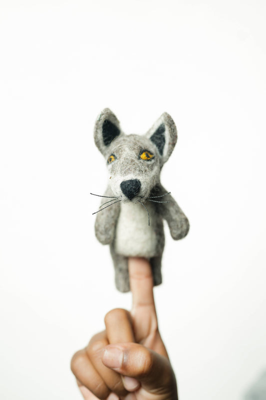 Gray fox finger puppet on a person's index finger against a white background