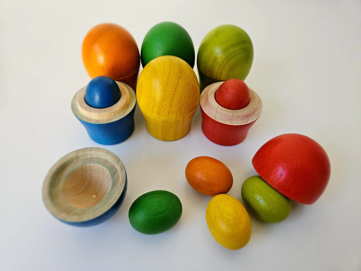 Rainbow colorful wooden sorting eggs an cups on a white back ground 