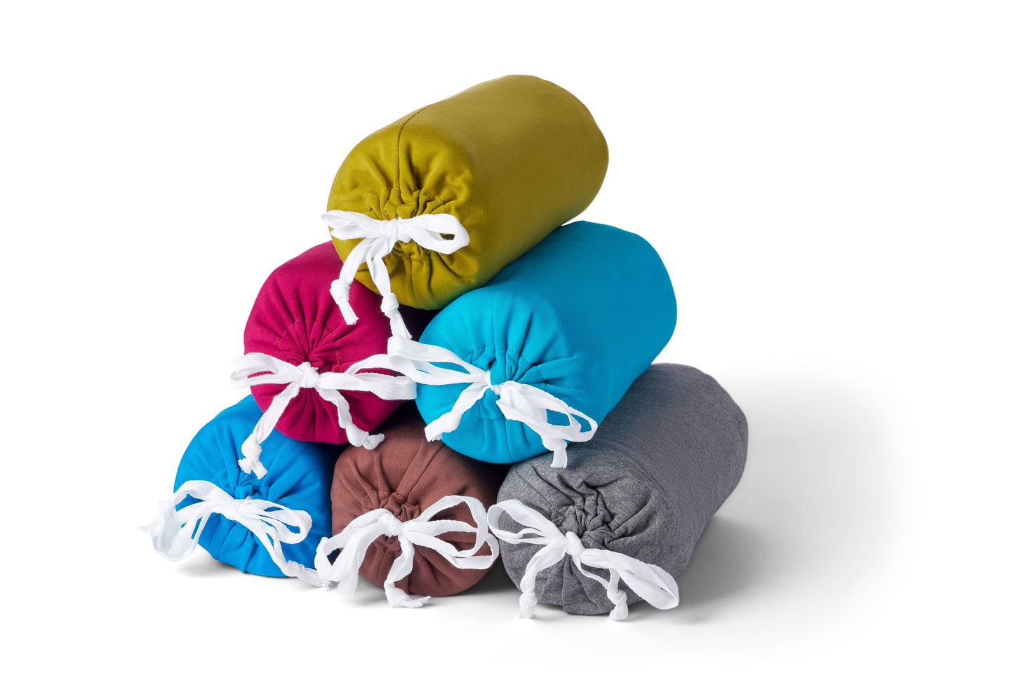 Stack of colorful fabric bags tied with white ribbons on a white background