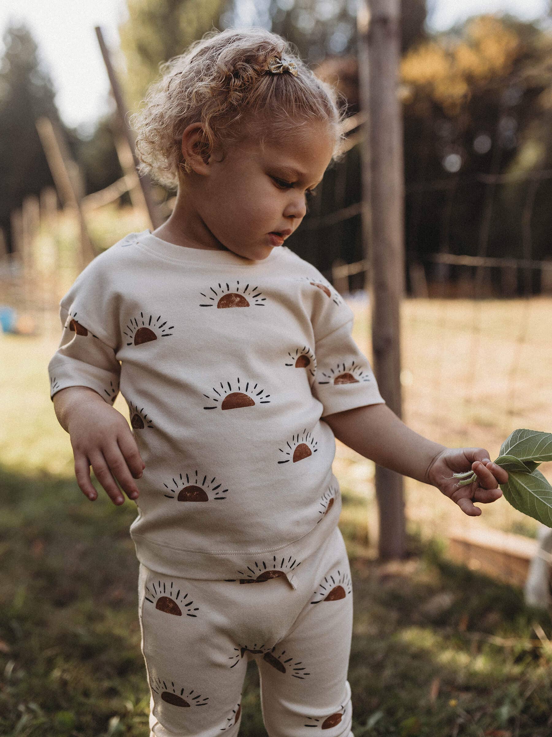 child playing outside wearing sun organic short sleeve tee