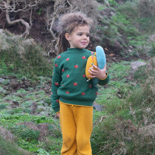 Child out side wearing an apple sweater