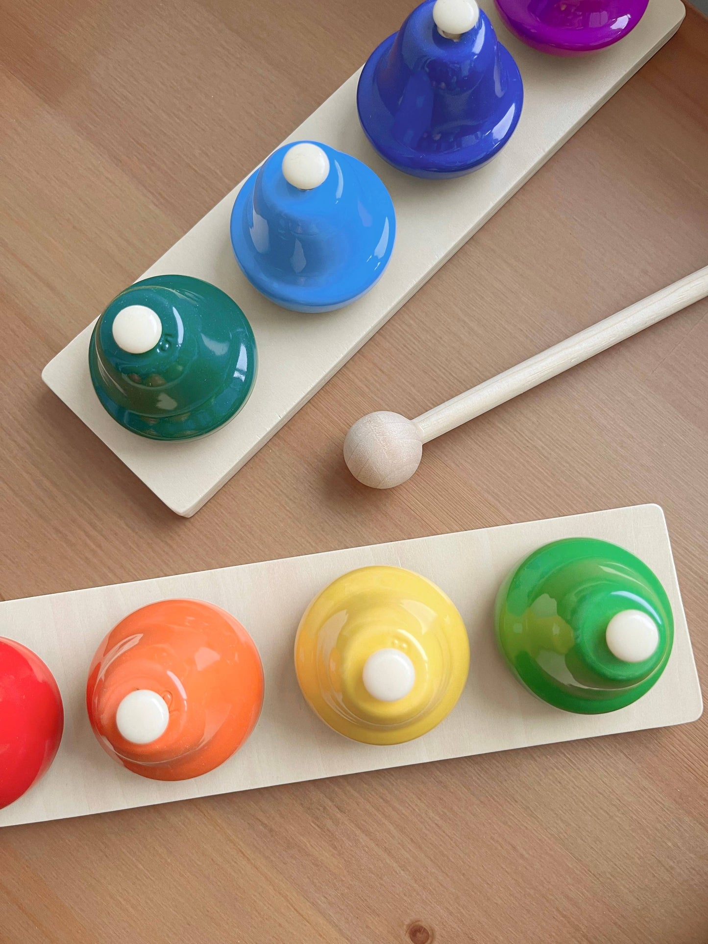 Colorful deskbells set with a wooden mallet on a wooden surface