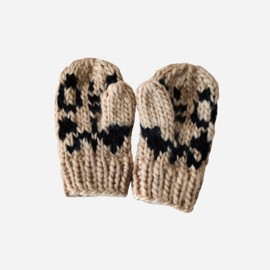 Pair of beige knitted mittens with black cheetah spots pattern on a white background