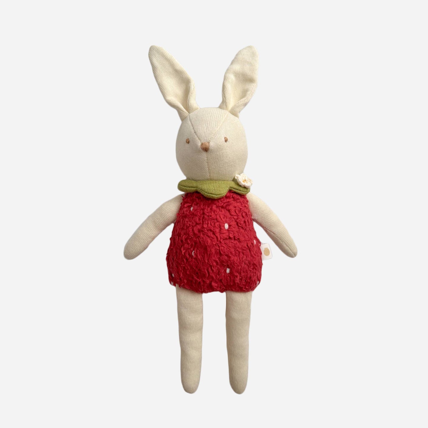 Stuffed bunny toy wearing a red dress on a white background
