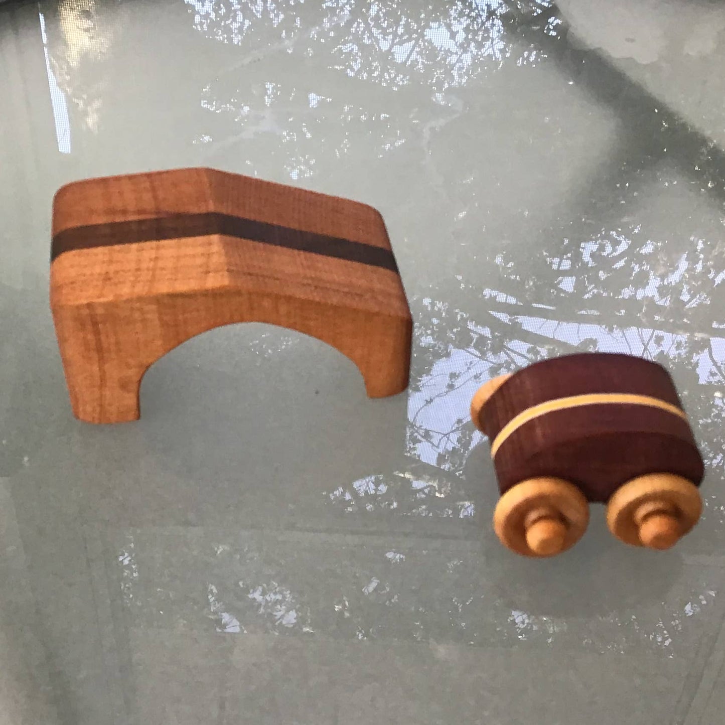 Wooden toy car with ramp on a glass surface