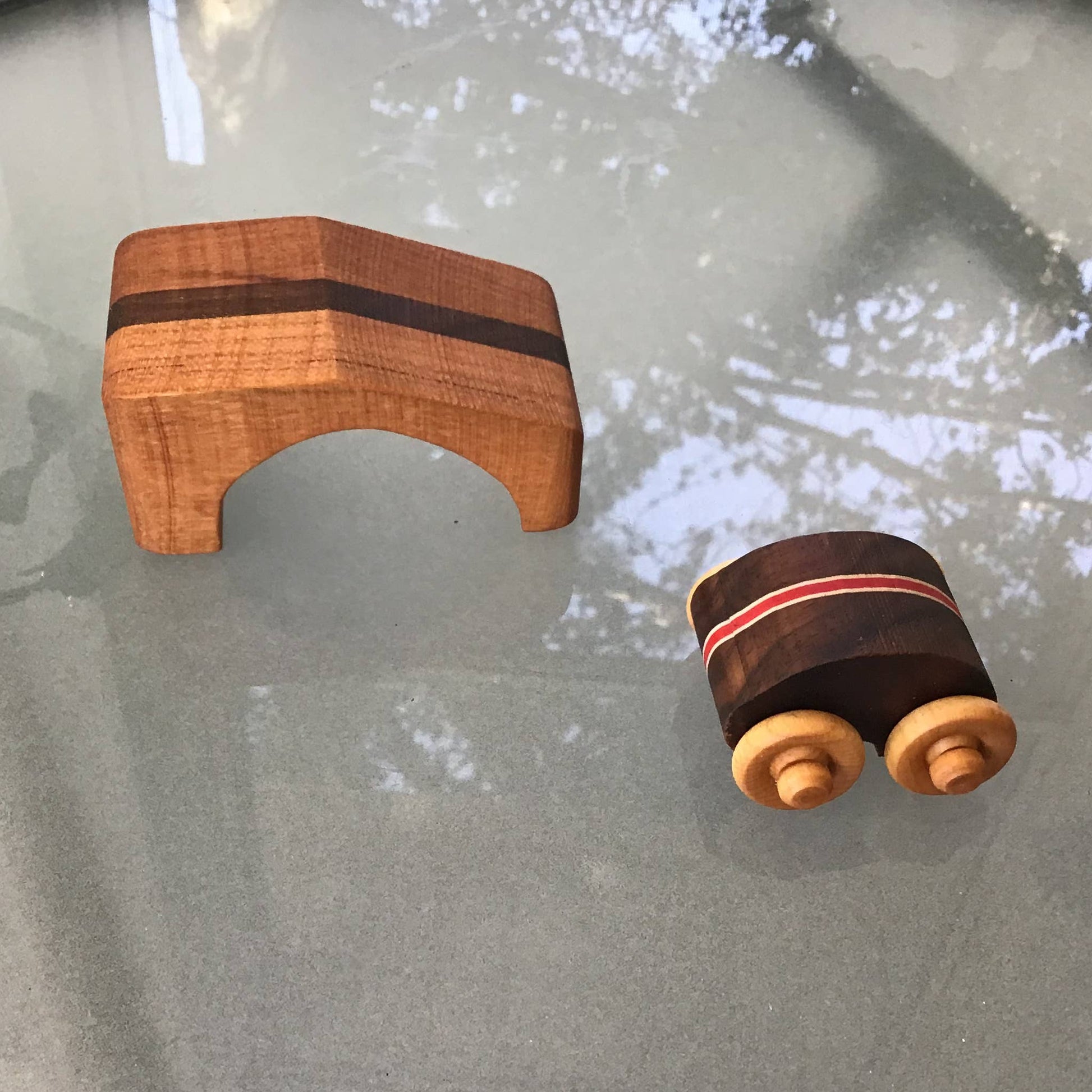 Wooden toy car with ramp on a reflective surface