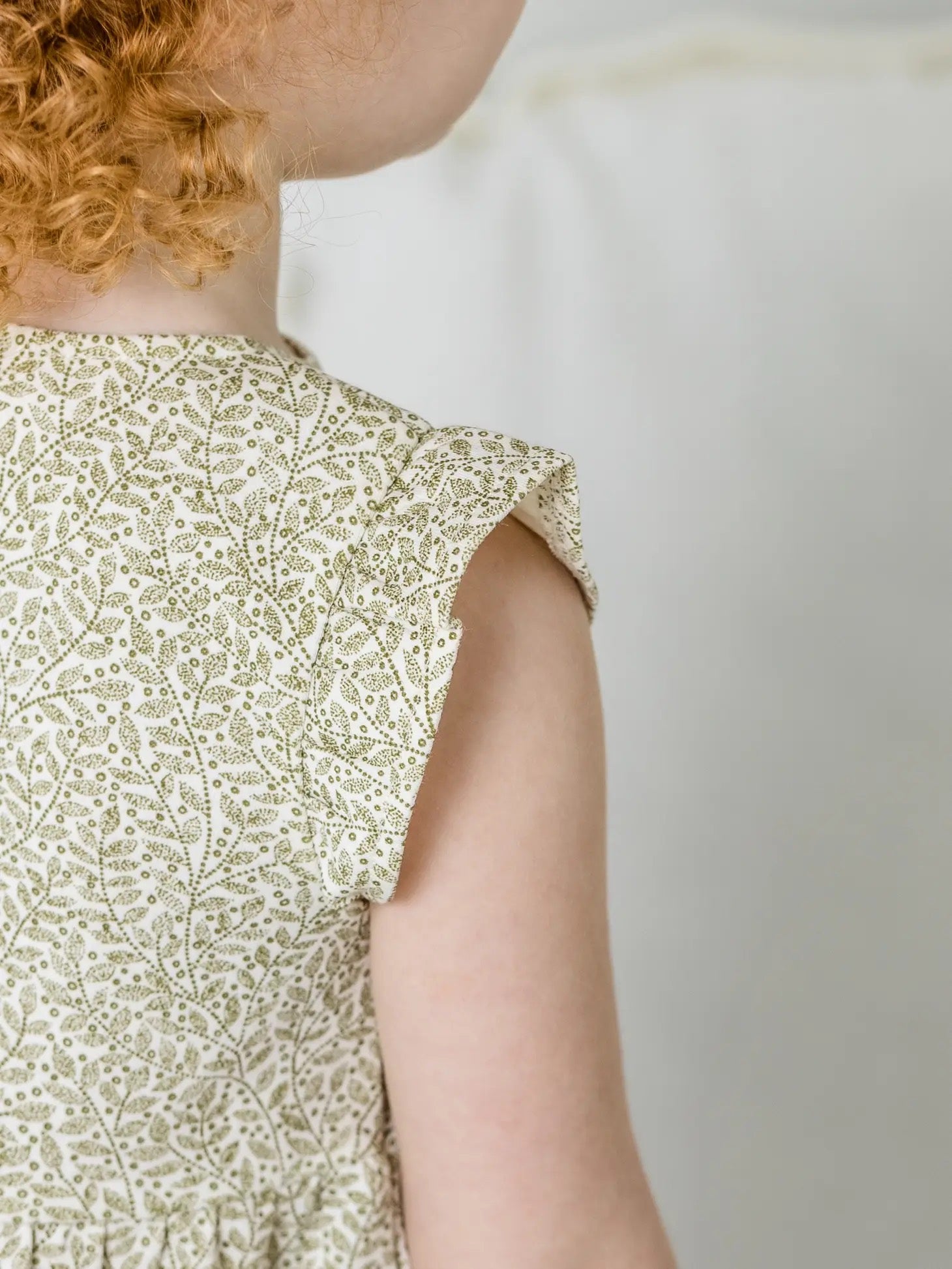 detail of child wearing Tilly Tiered Dress in Fern + Ivory