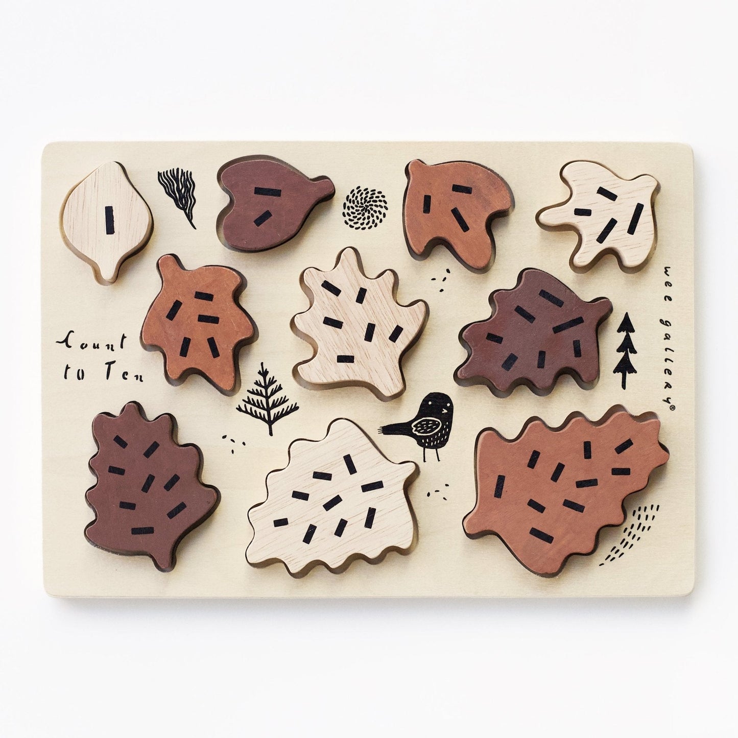 Wooden leaf-shaped puzzle on a light wooden board with nature-themed illustrations.