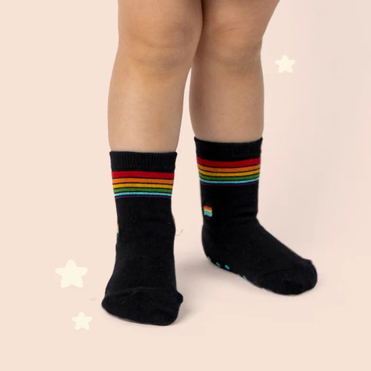 Socks that save LGBTQ lives in black with rainbow stripes on toddler feet