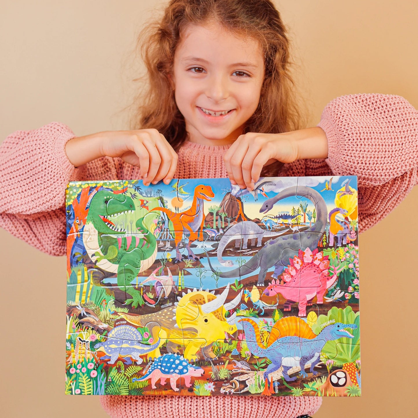 child holding a dinosaur land puzzle by eeBoo