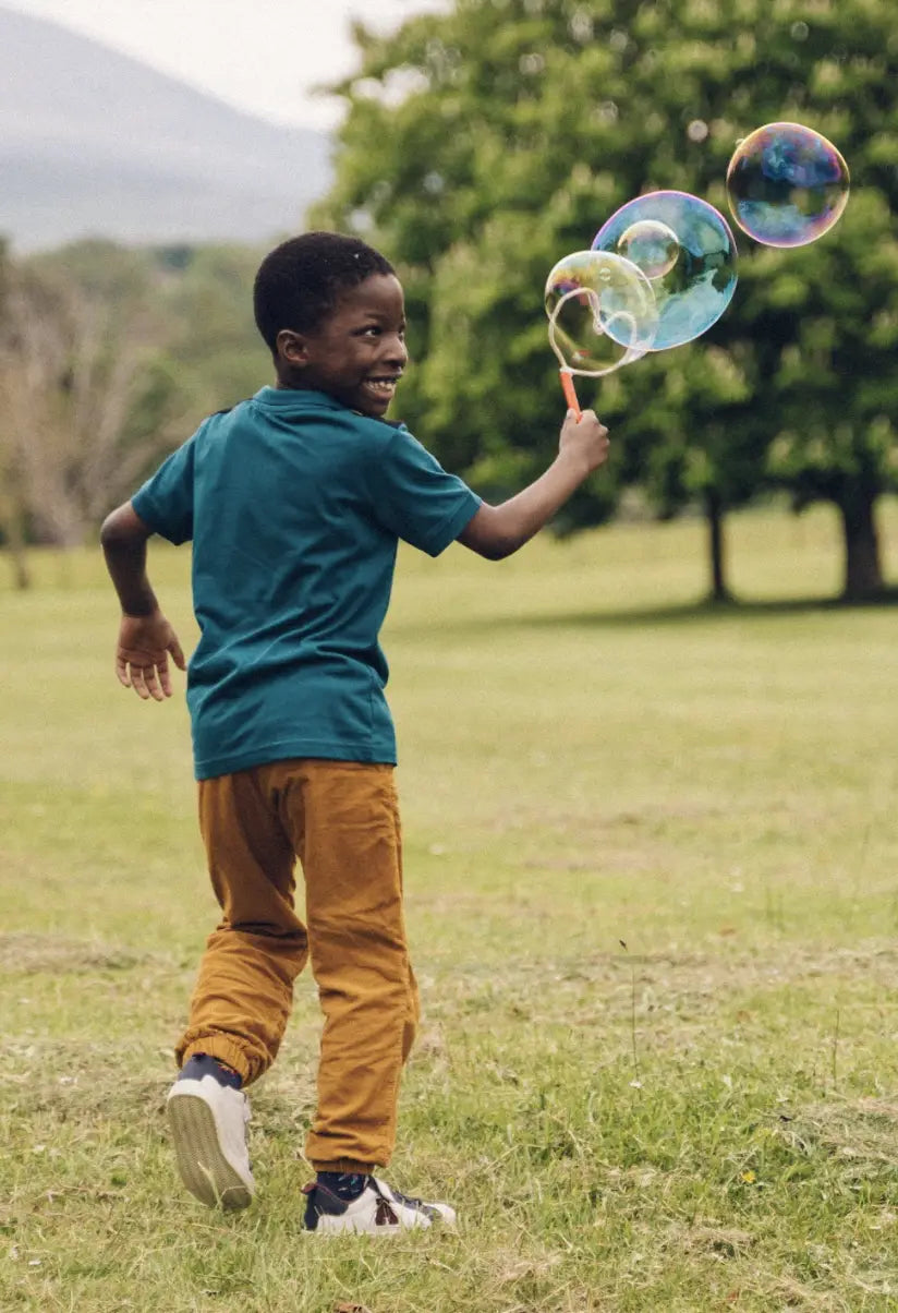 child running blowing bubbles with hand wand
