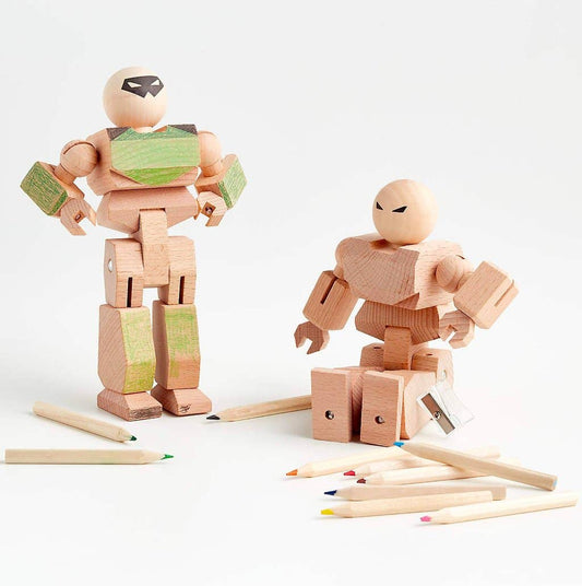 Two wooden robot toys with colored pencils on a light background