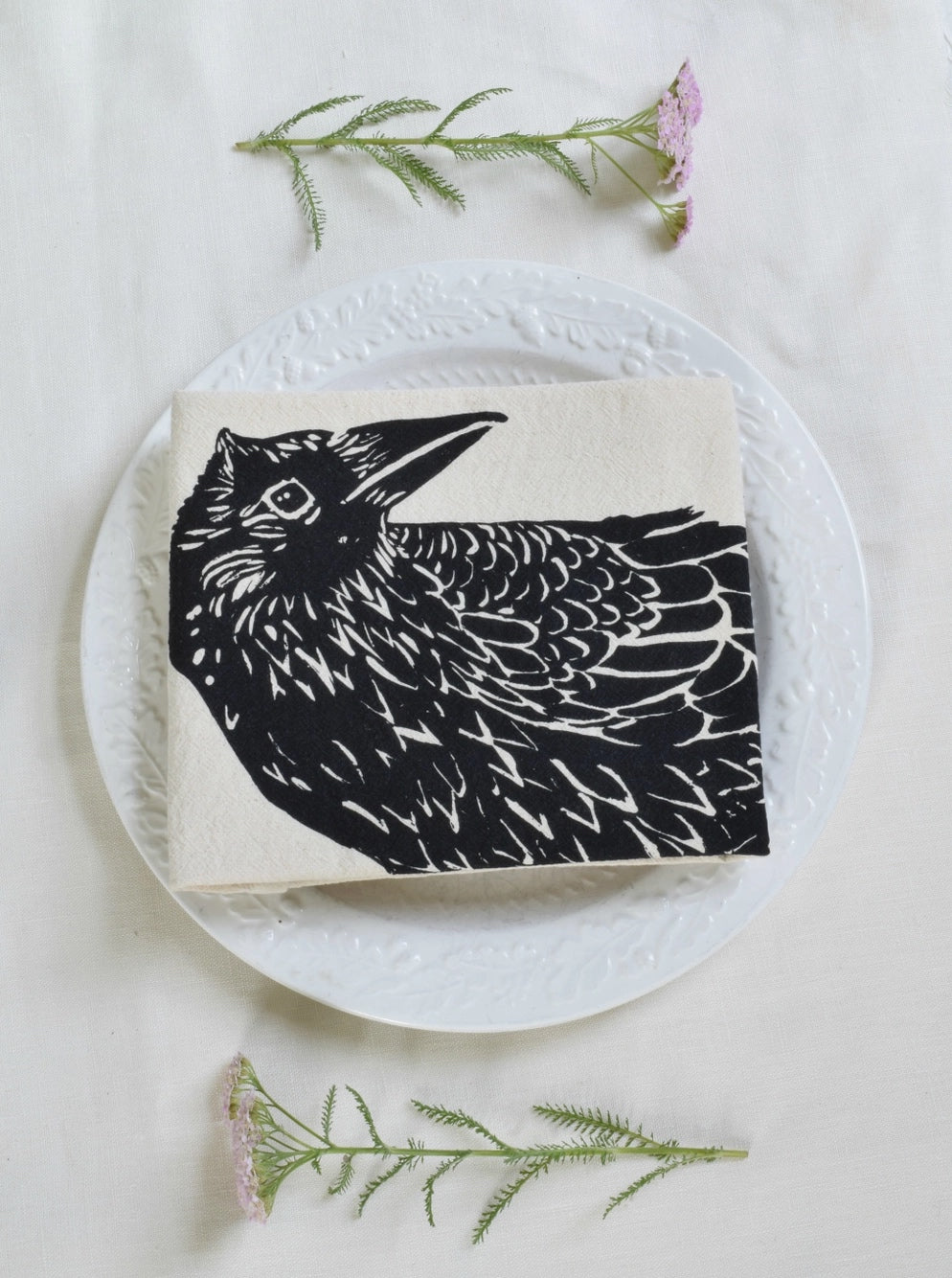 organic cotton crow tea towel folded on a plate