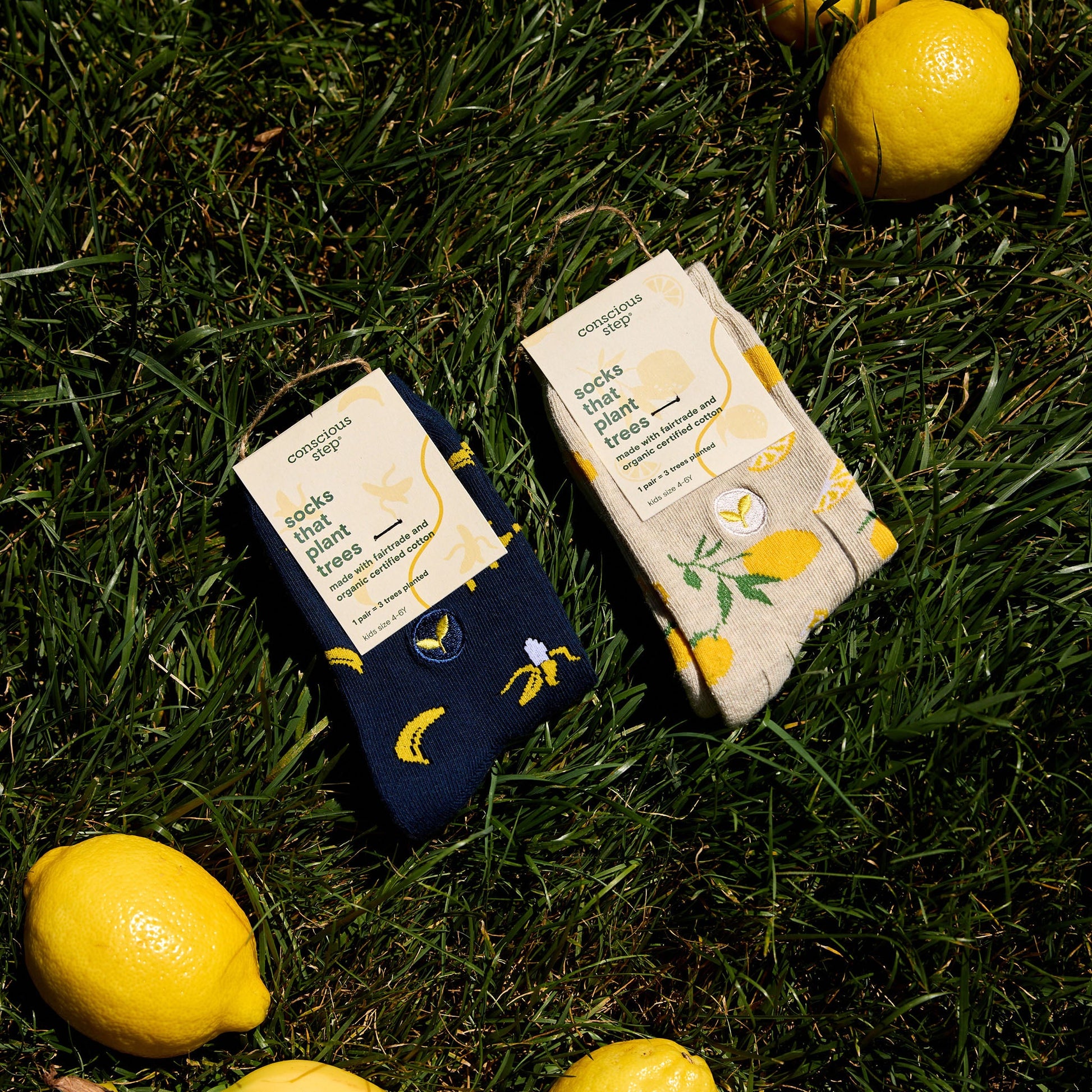 Two packages of 'dock that plant free' on grass with lemons around