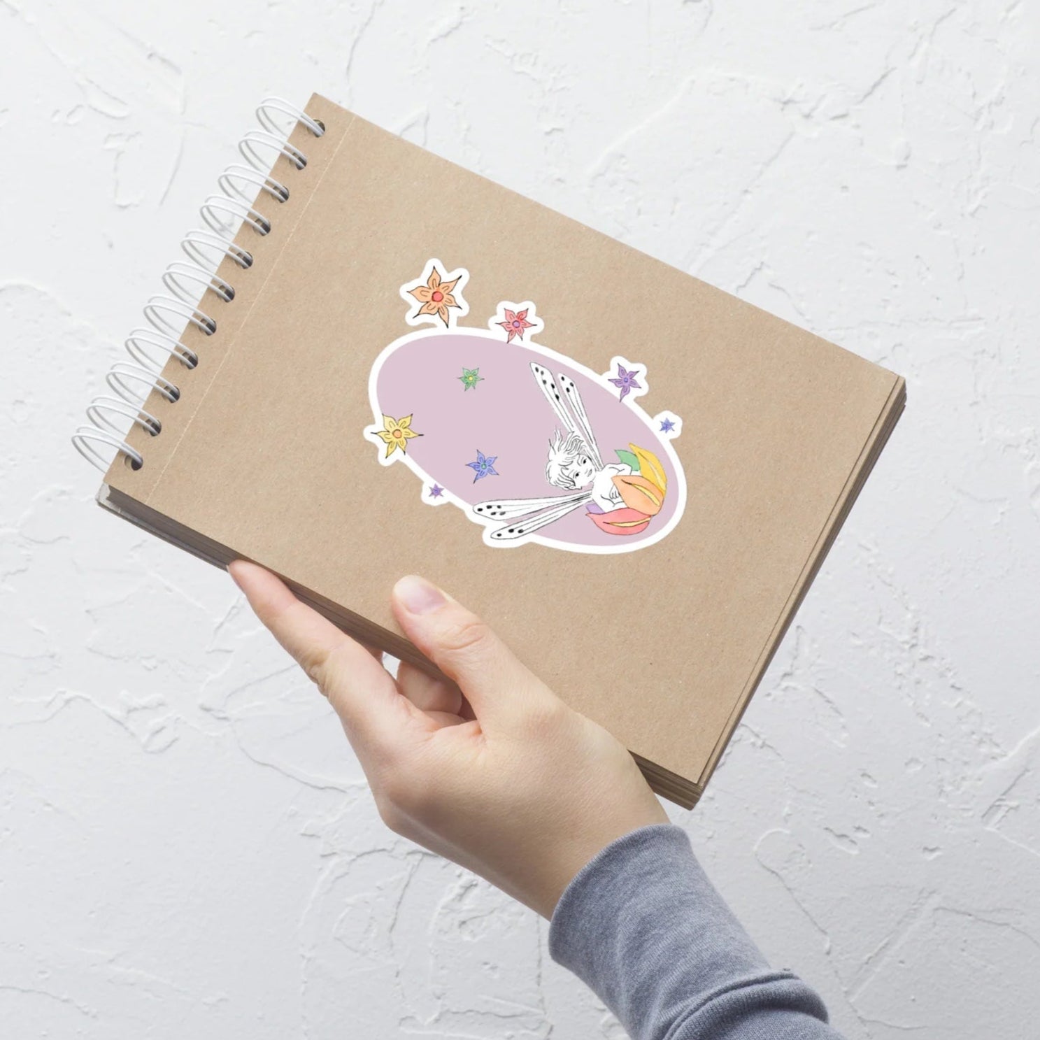 rainbow fairy sticker with lavender background on a flip notebook