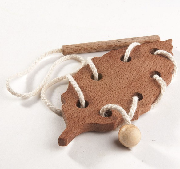 Wooden leaf-shaped toy with string on a white background
