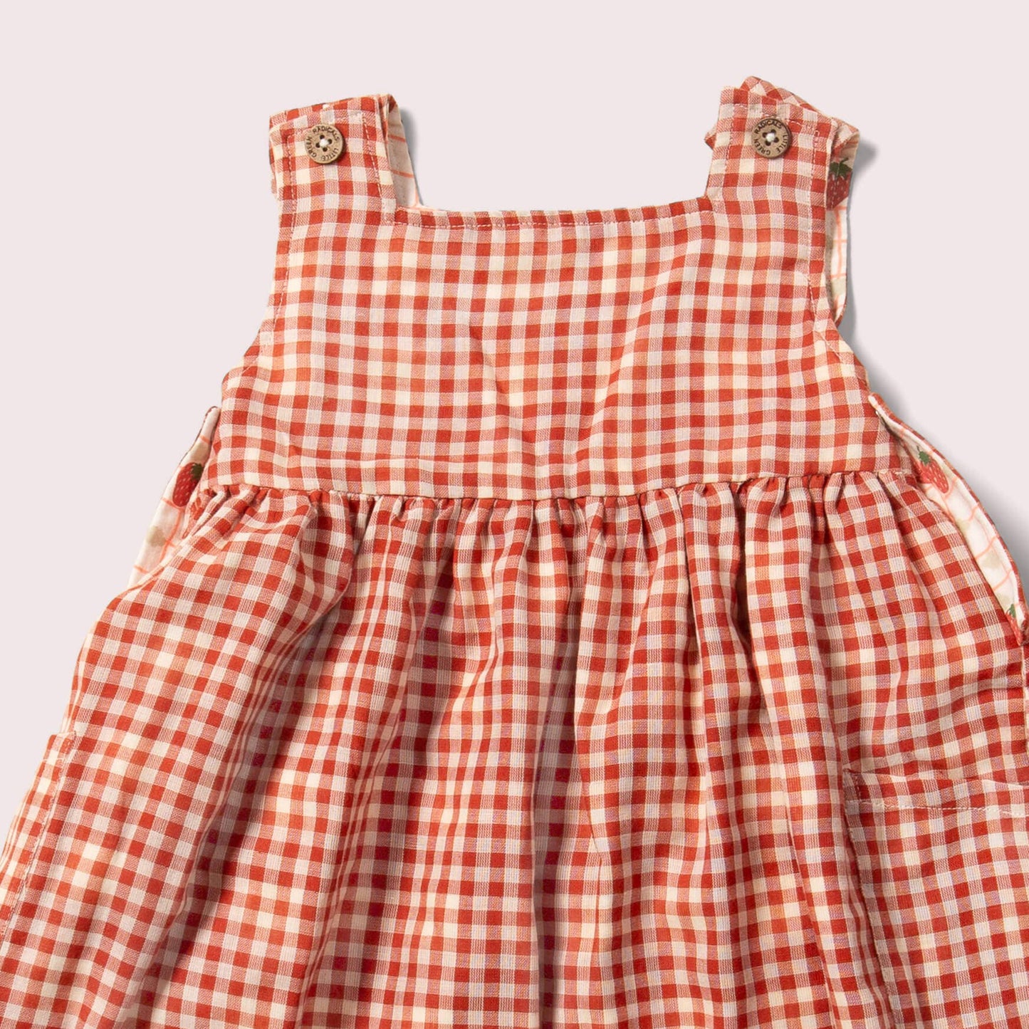 button detail for reversible strawberry pinny dress on the red checks side