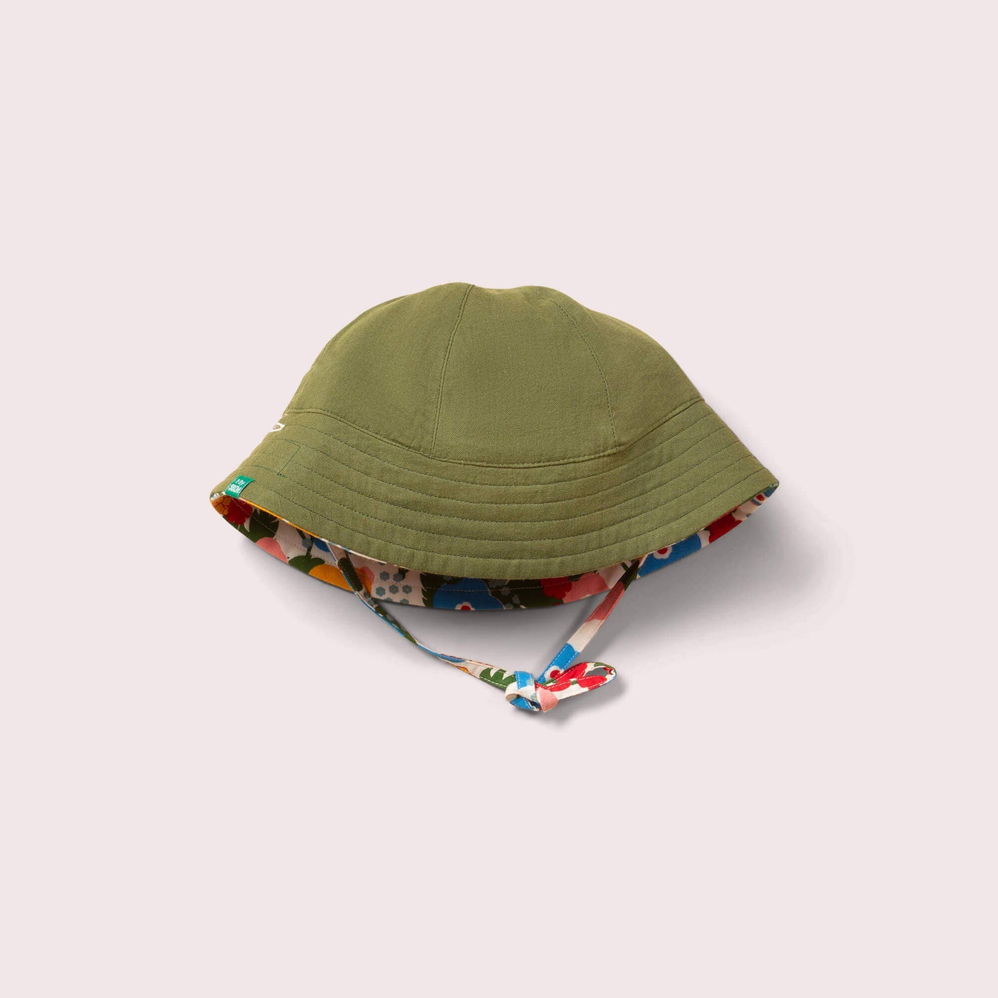 Green sun hat with floral interior lining on a light gray background