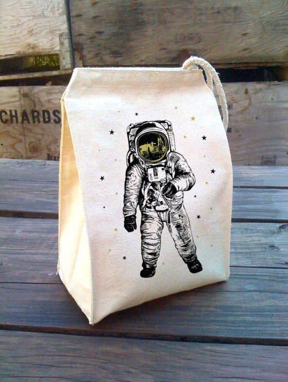 Canvas lunch bag with an astronaut design on a wooden table