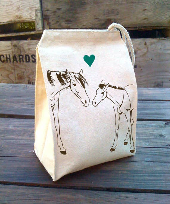 Canvas lunch bag with horses illustrations and a heart on a wooden table