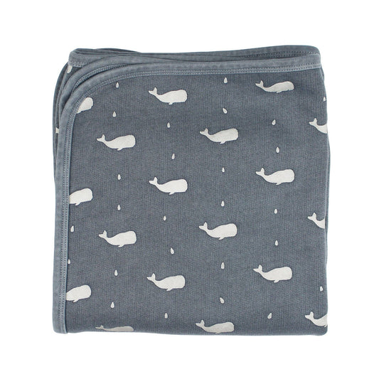 Folded blanket with whale pattern on a white background