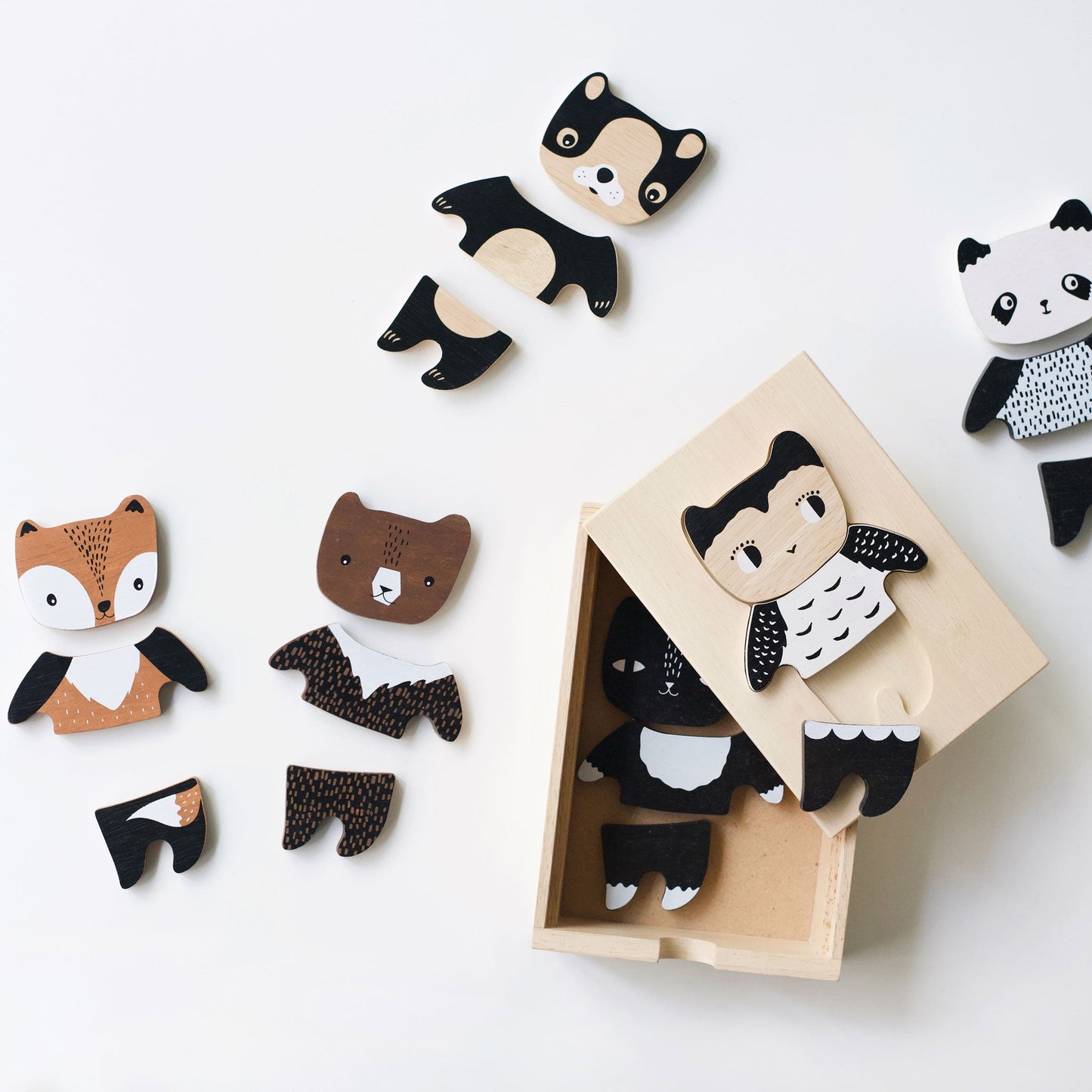 Wooden animal toys with a panda figure in a box on a white background