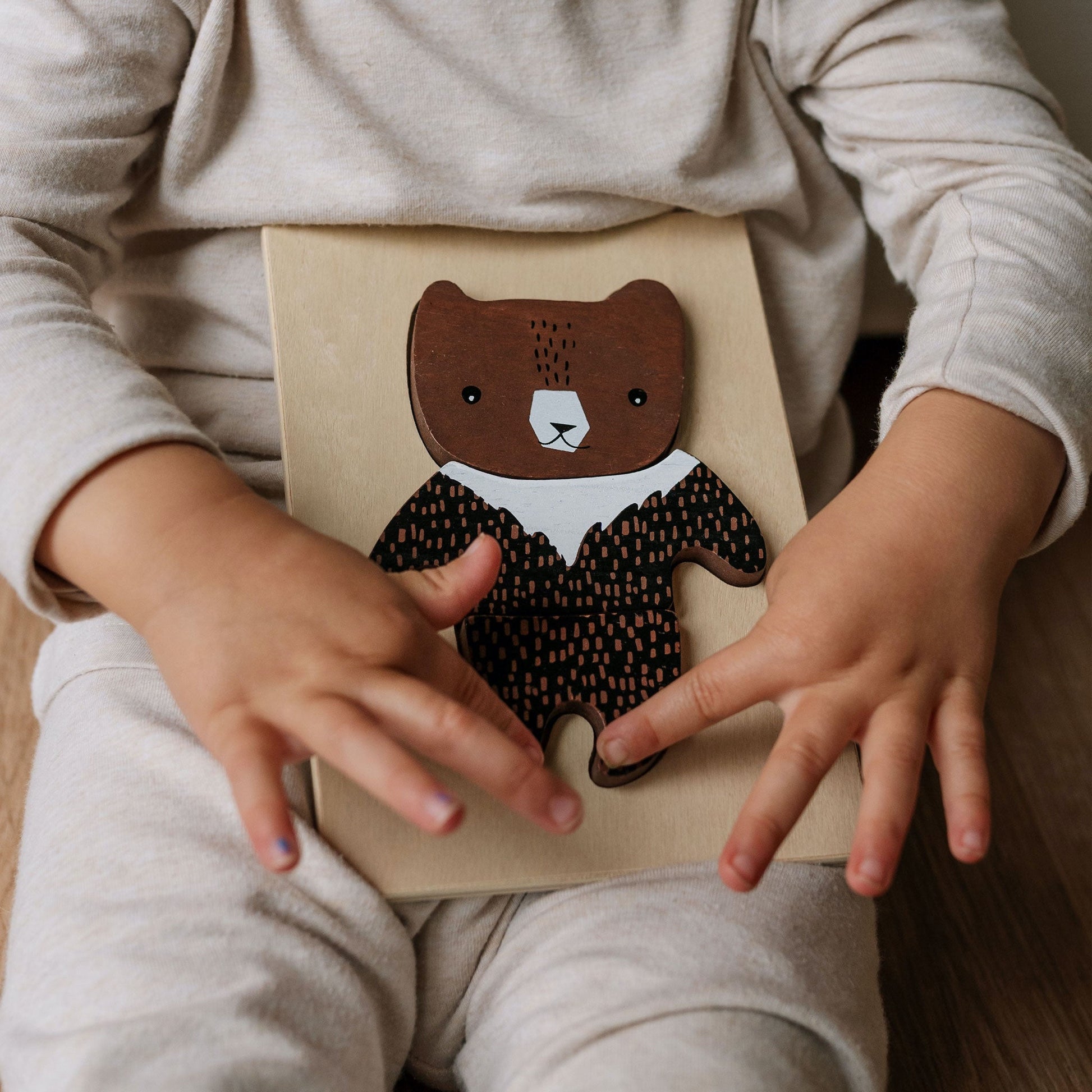 Child's hands holding a book with a bear design on the cover