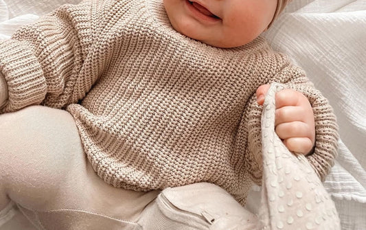 a baby wearing an organic knit oatmeal sweater by mama siesta