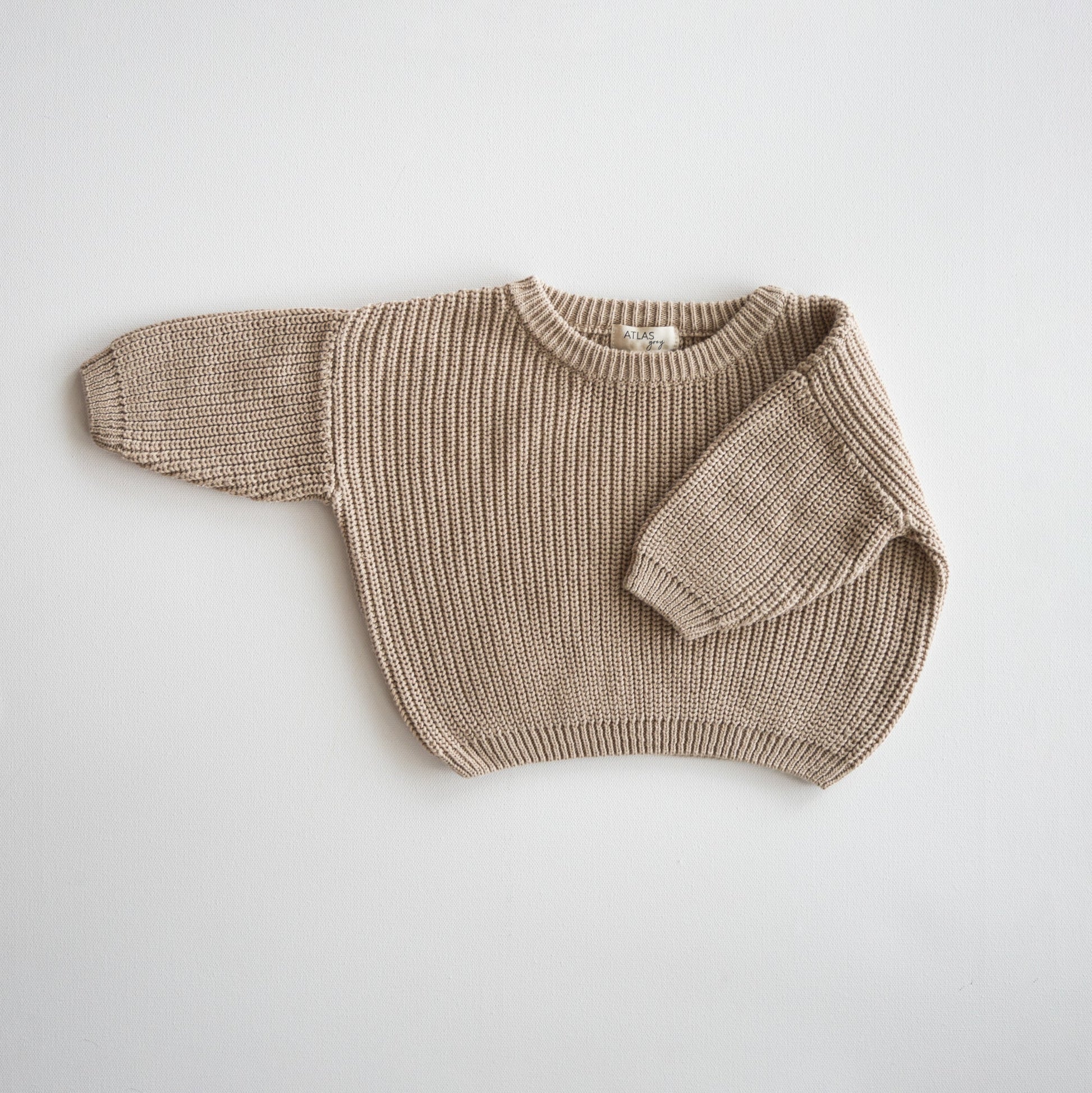 Beige knitted sweater on a light gray background
