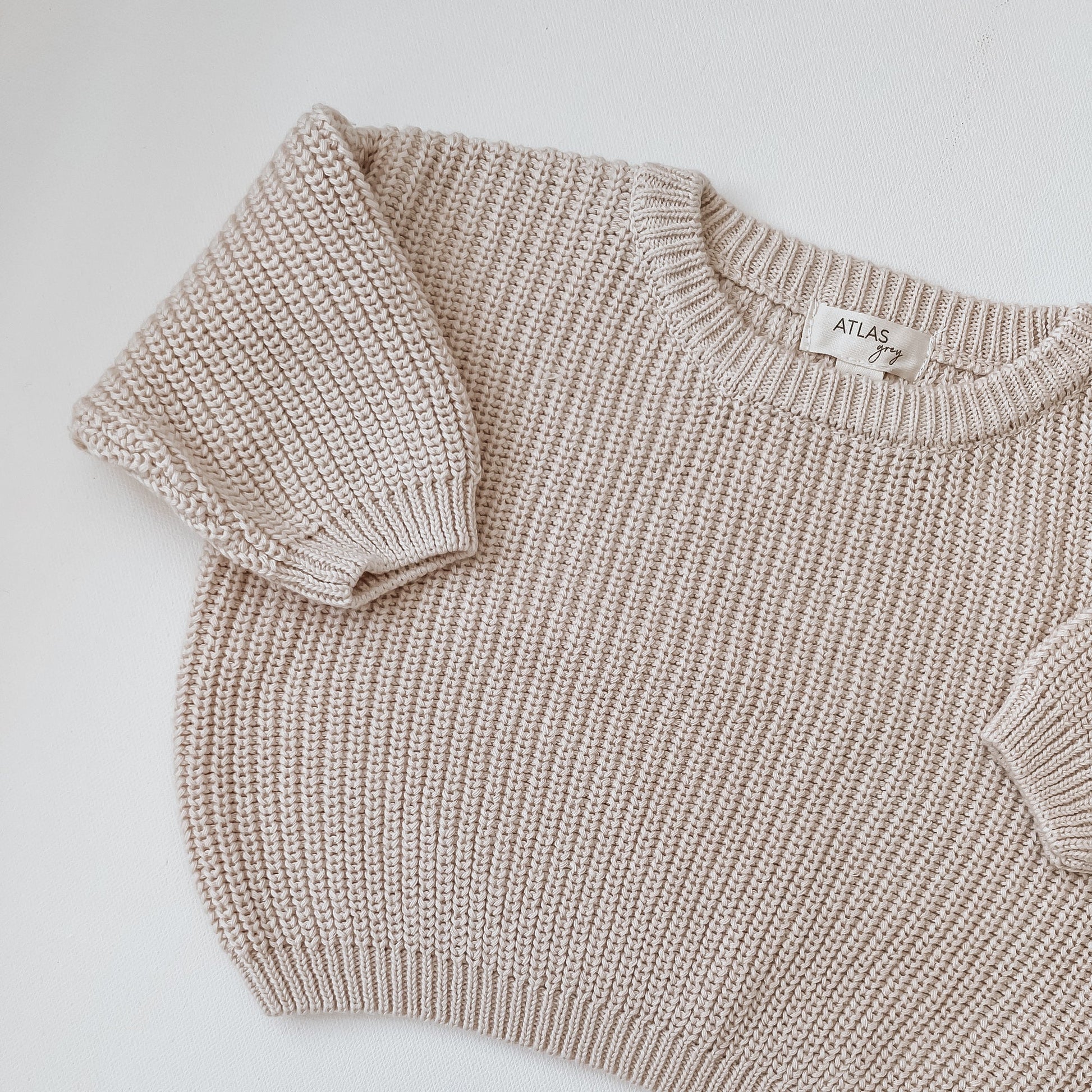 Knitted sweater with a visible brand label on a light background